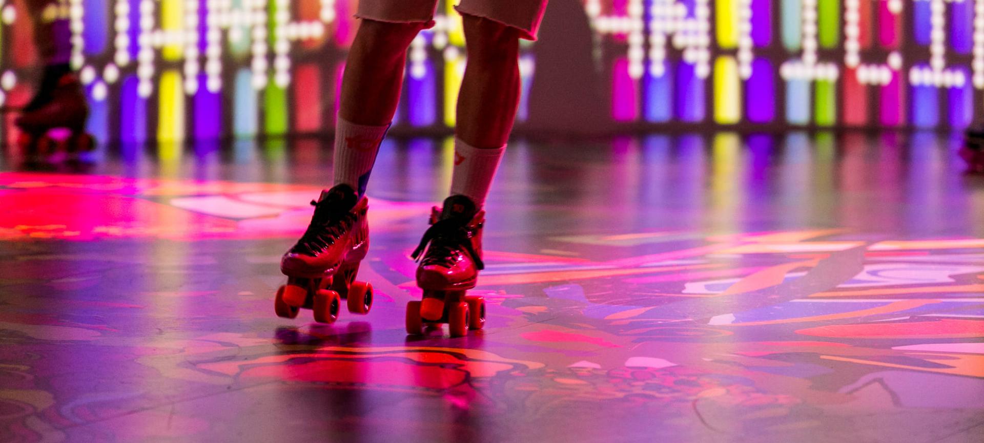 Someone rollerskating on a colourful floor