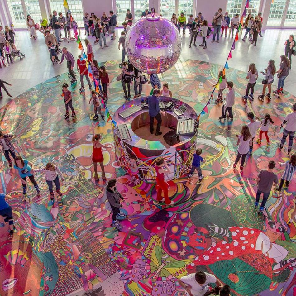interior view of crowd of people dancing and roller skating with bright, vivid colors