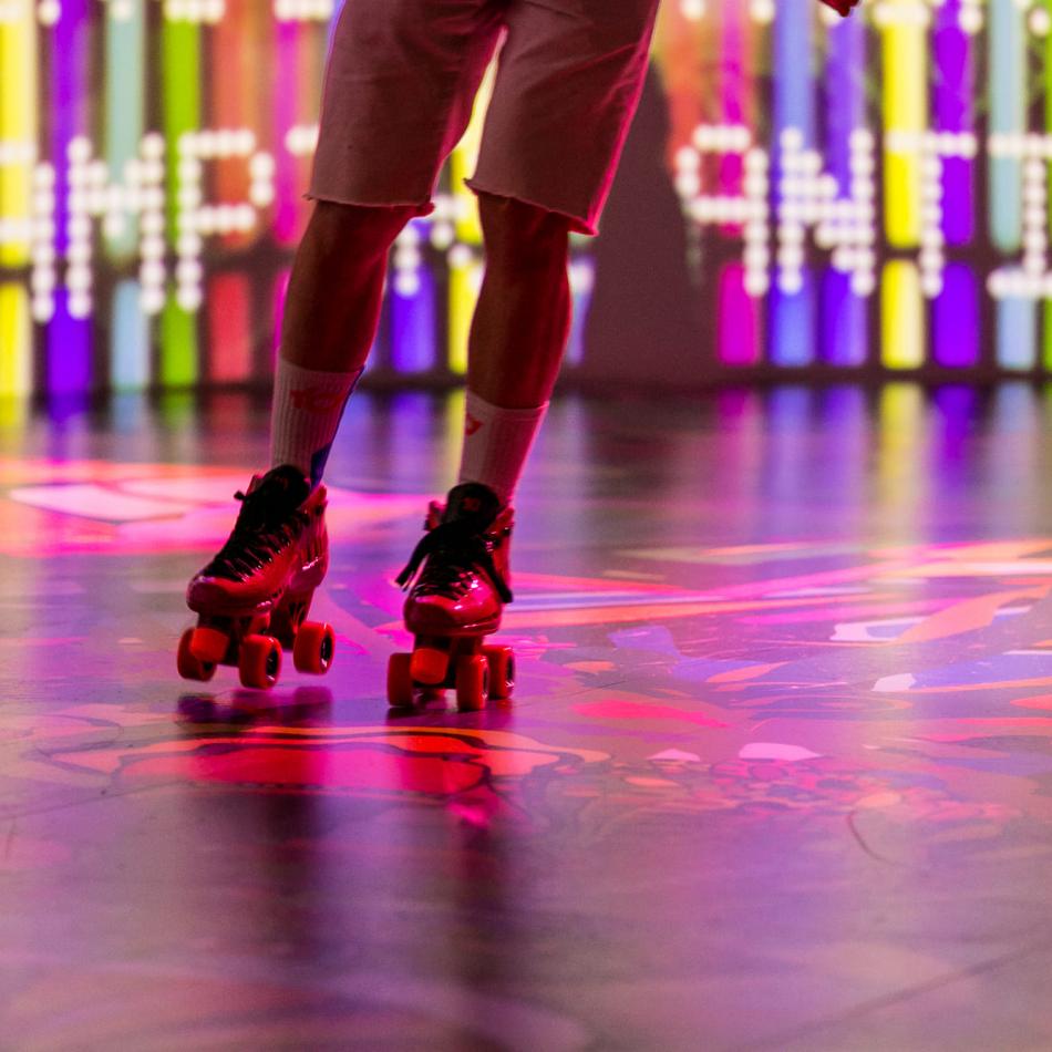 Someone rollerskating on a colourful floor