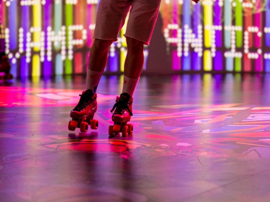 Someone rollerskating on a colourful floor