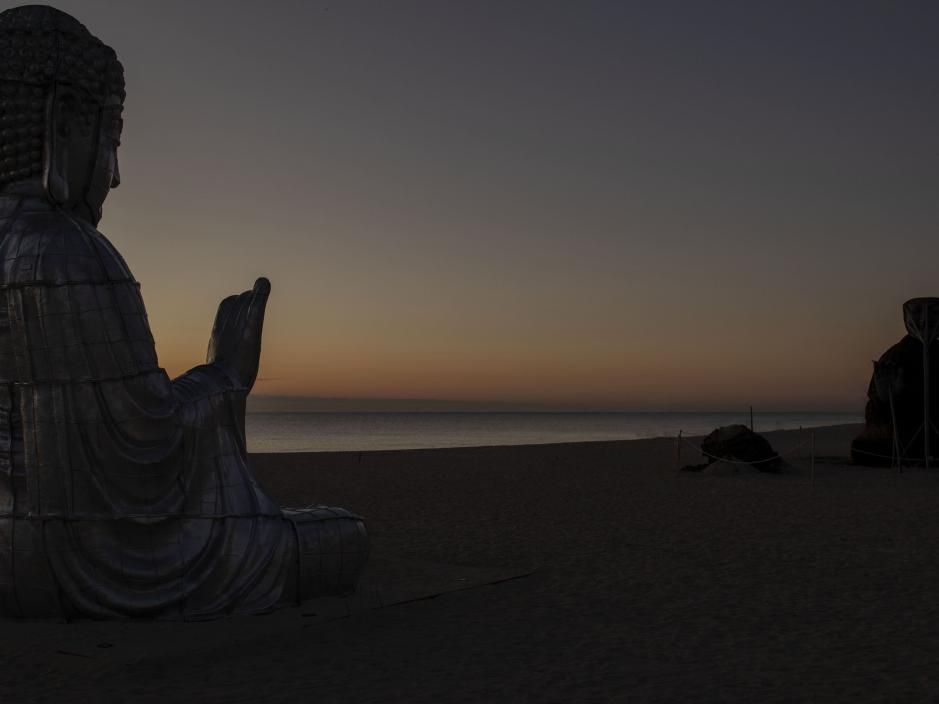 two sculptures facing each other on the beach