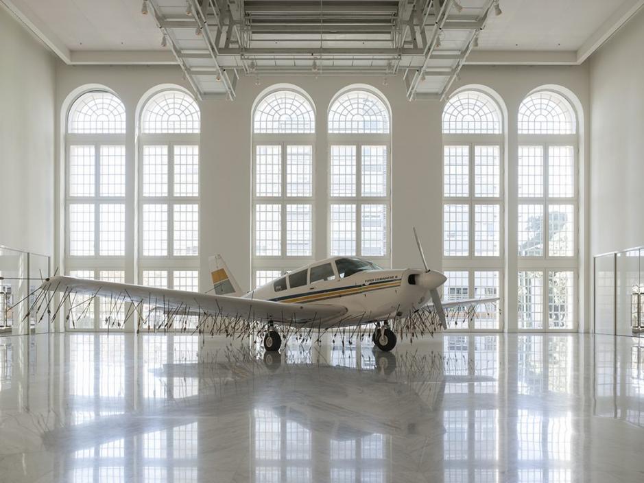 A plane in a white room with arrows covering the under belly