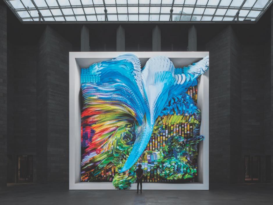 large colorful art installation in white frame against wall