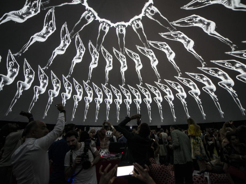 People viewing an art installation on a dome ceiling