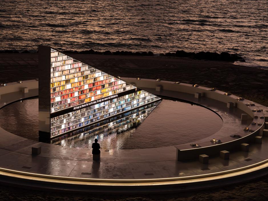 A man sitting in front of the rotating library in Miami Beach