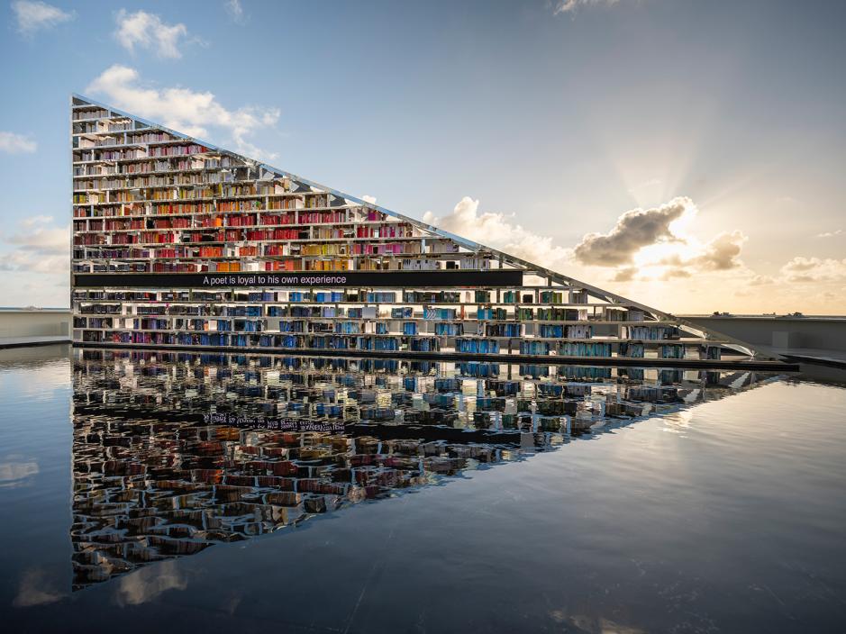 Side view of the rotating library reflecting into the water in Miami Beach