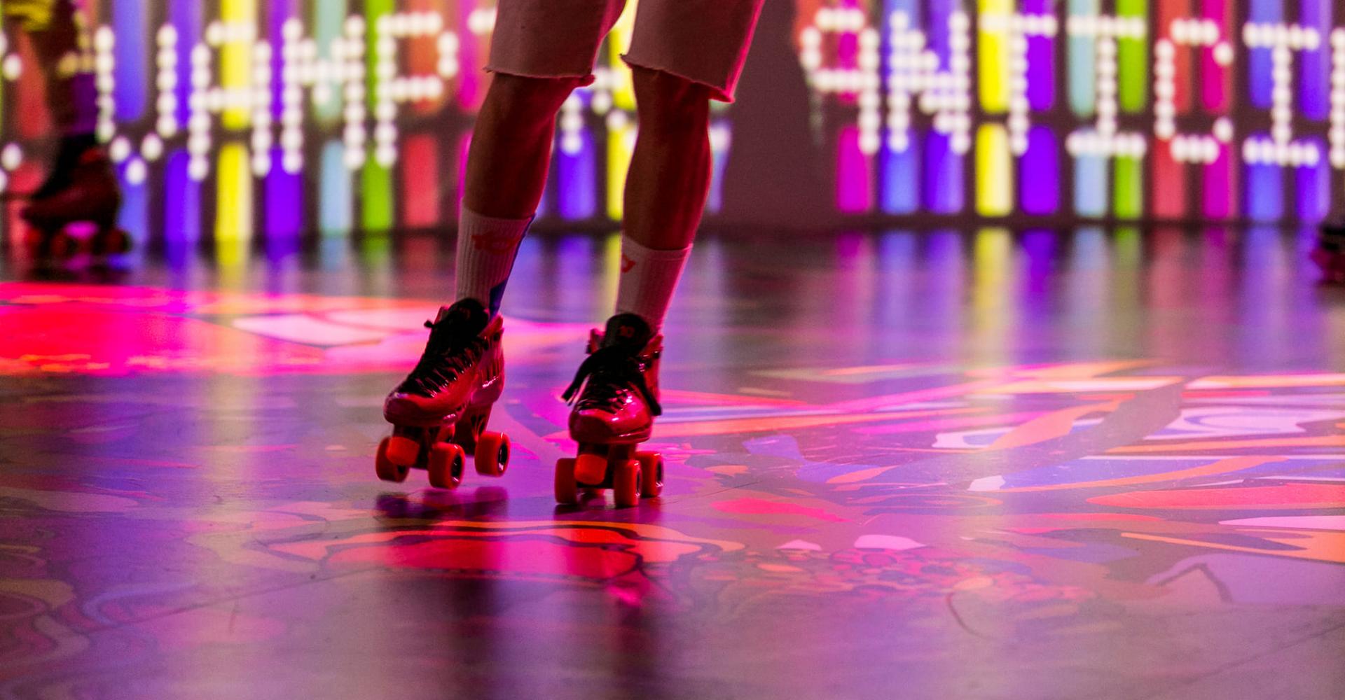 Someone rollerskating on a colourful floor