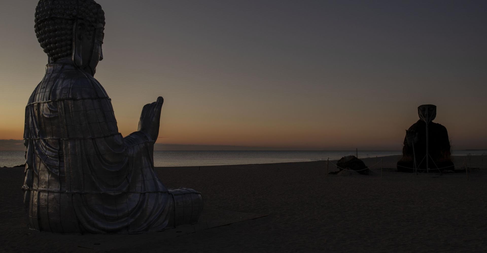two sculptures facing each other on the beach